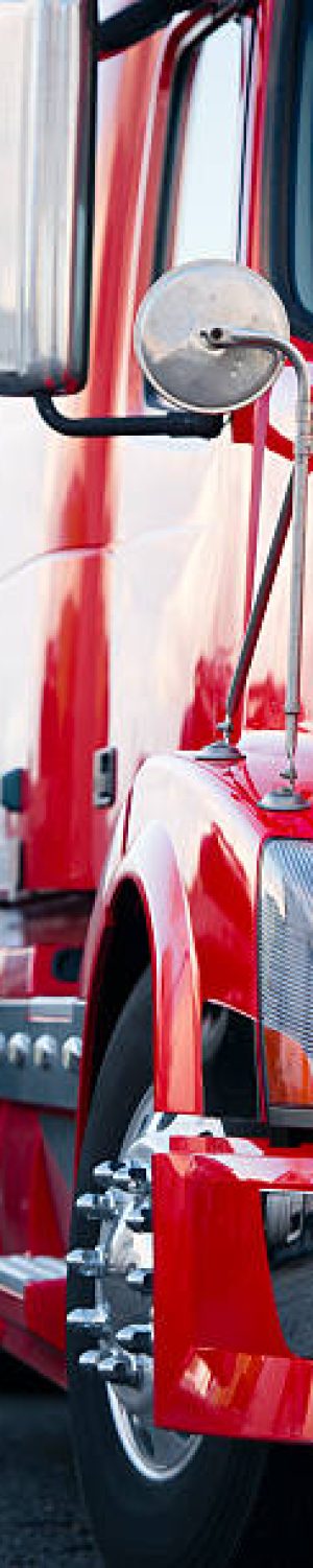 Beautiful modern and stylish semi truck trailer loaded with pipes with reflection of sunlight on the shiny surface of the cab. Chrome parts highlight the style of the owner operator.